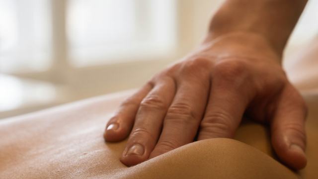 Massoterapeuta fazendo massagem nas costas de uma cliente